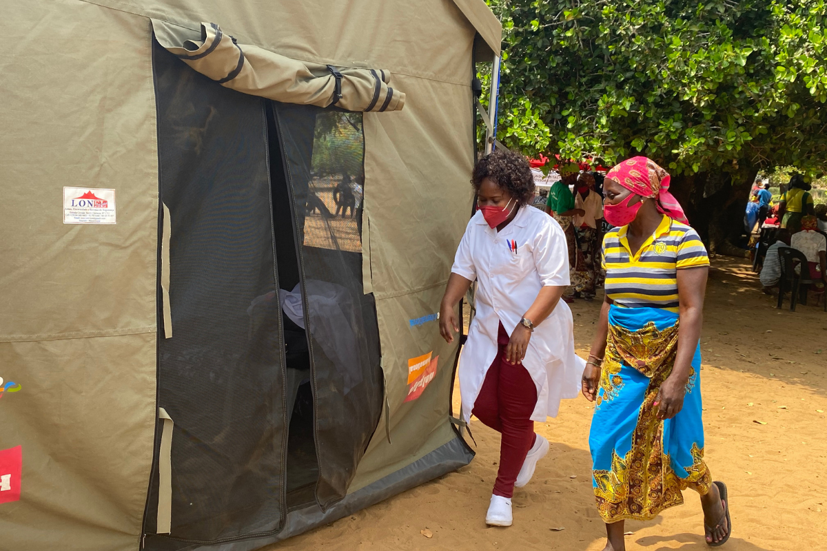 Nurse and patient walking into medical tent