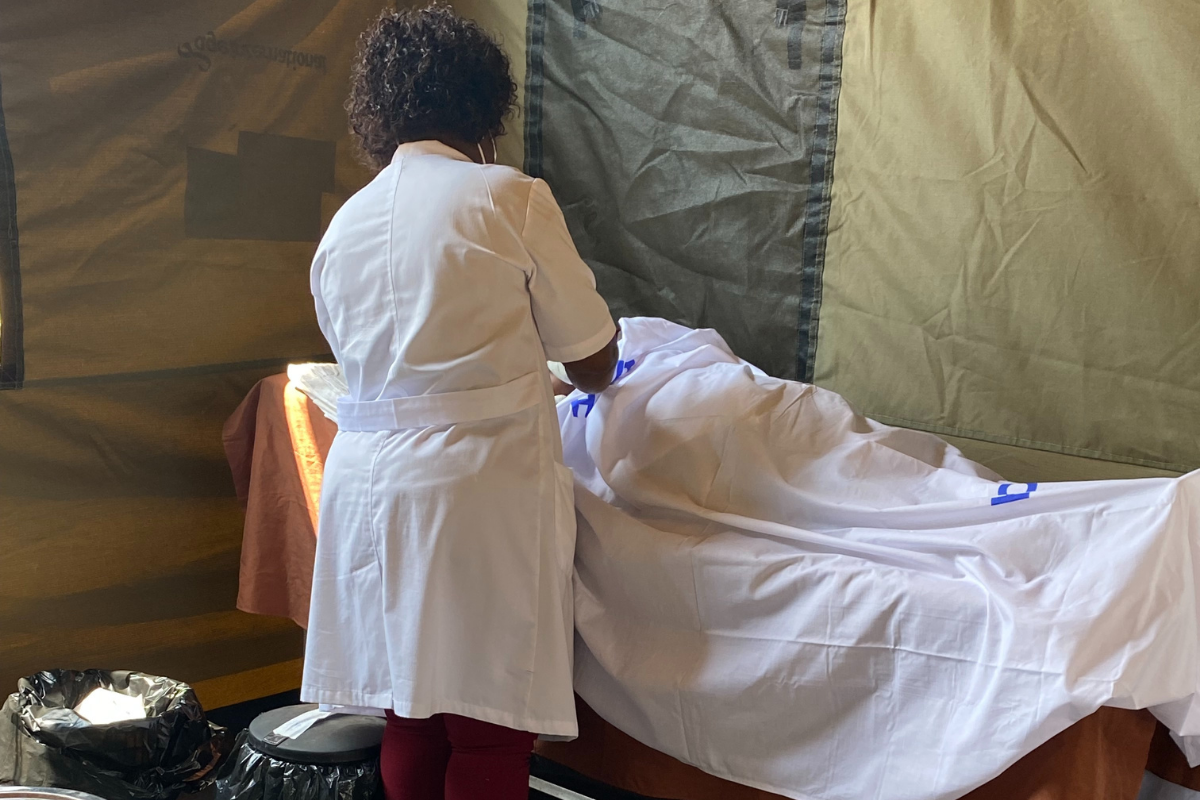 Nurse giving a screening inside a medical tent