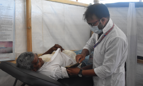 A healthcare worker treats an older person in Cox's Bazar, Bangladesh