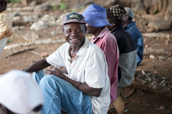 Older men wait for information about their rights to access basic services in Mozambique