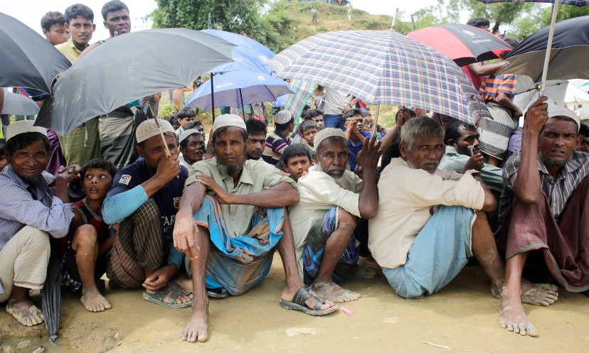 Older Rohingya refugees shelter from the rain in a refugee camp in Bangladesh.