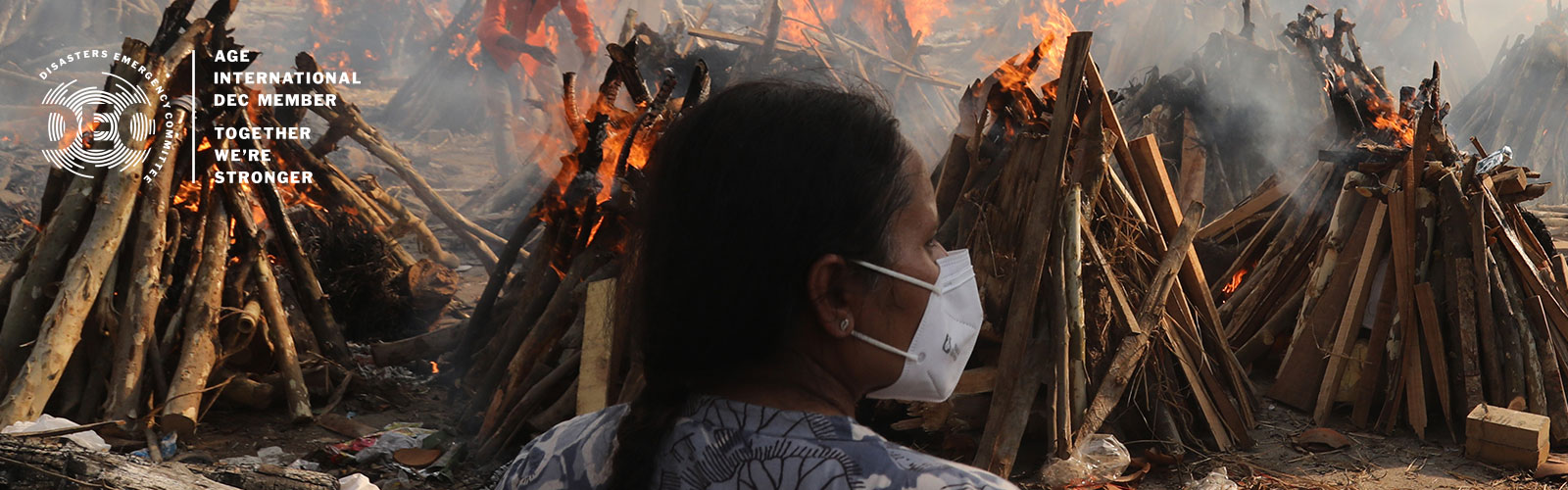 A family member looks on as several funeral pyres of patients who died of Covid-19 burn during the mass cremation at Ghazipur cremation ground in New Delhi, India.